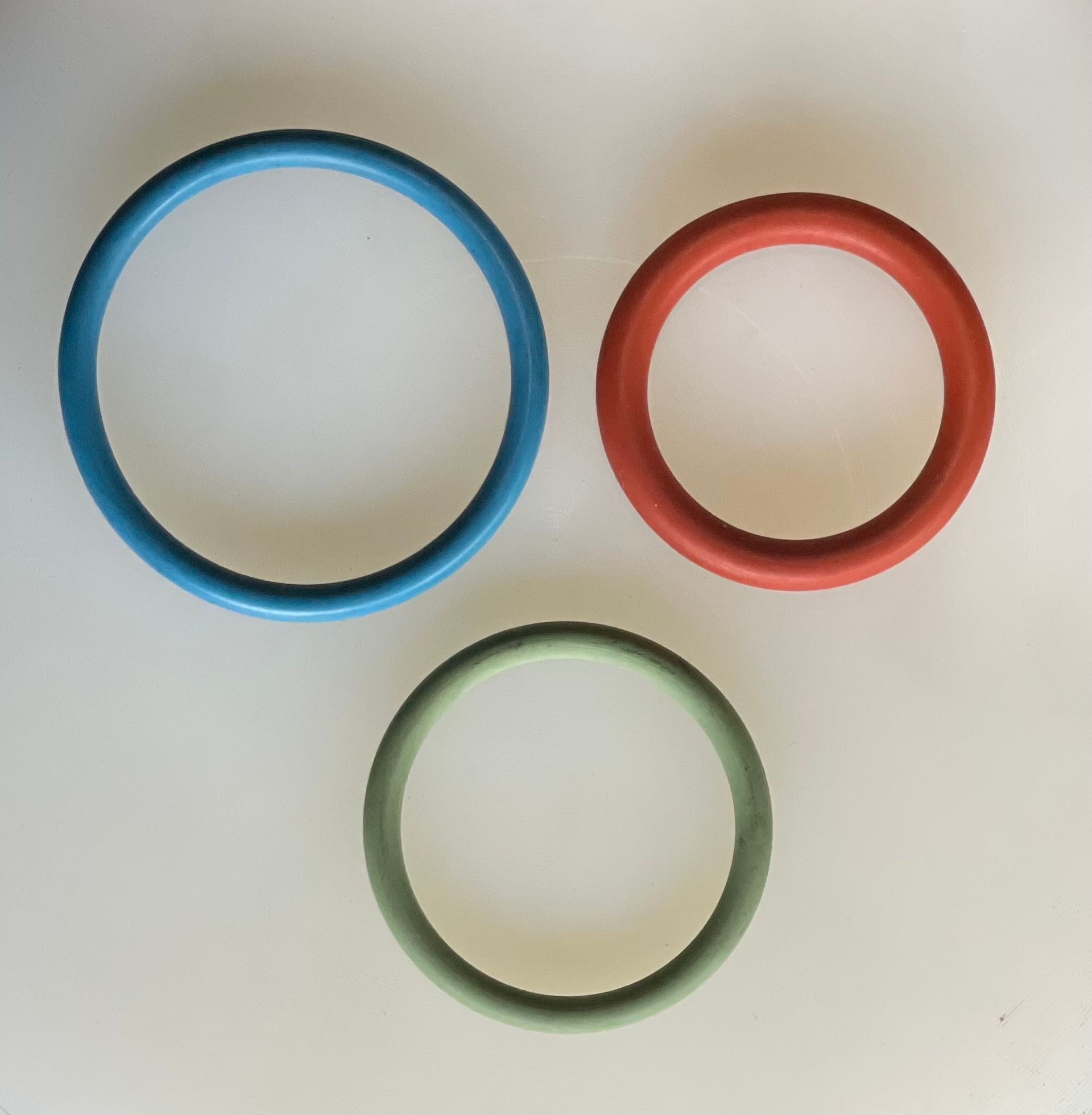 Tre anelli colorati – blu, rosso e verde – disposti su uno sfondo chiaro.