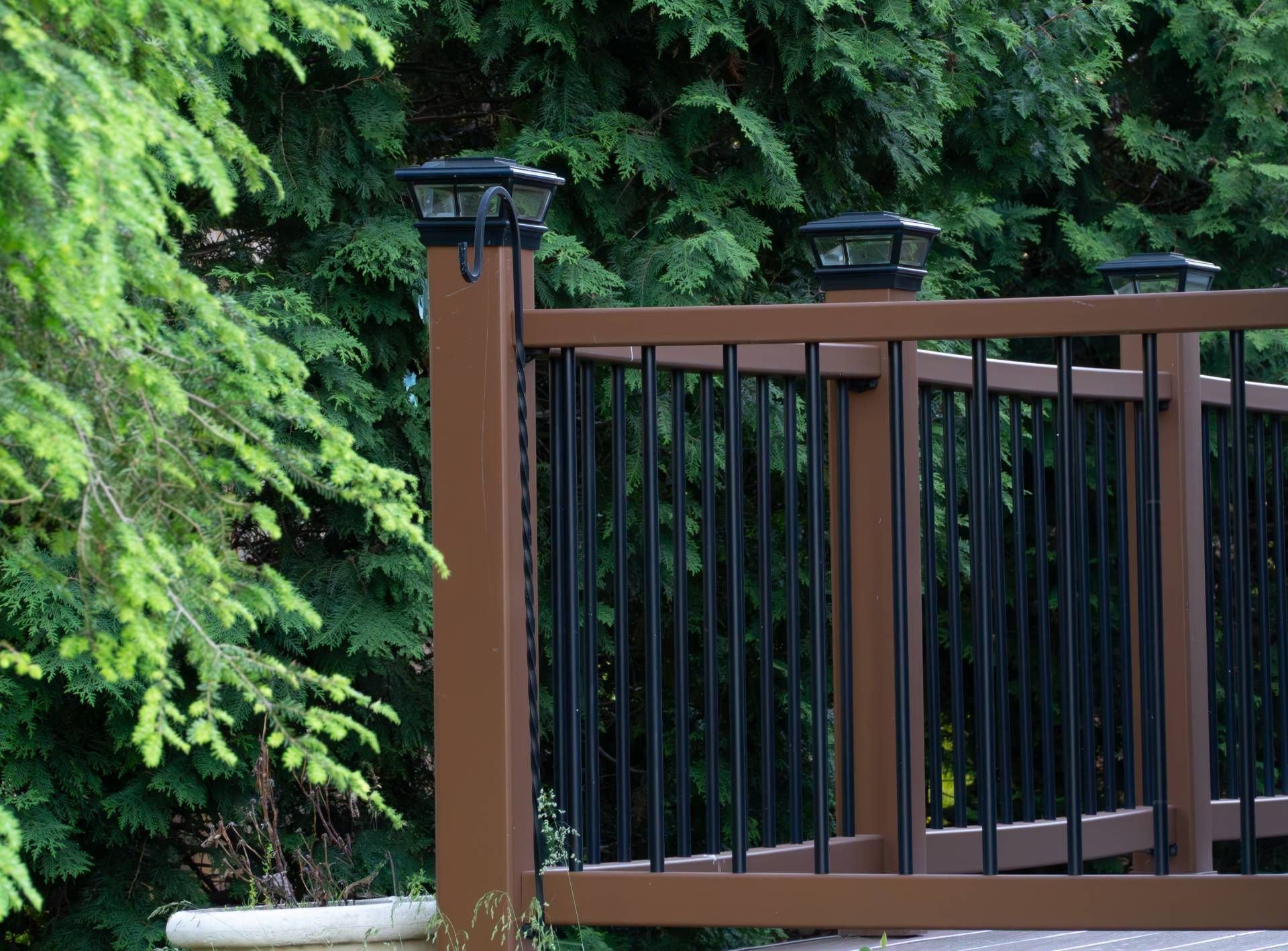 A detailed image of a modern custom deck with brown composite materials and black railing