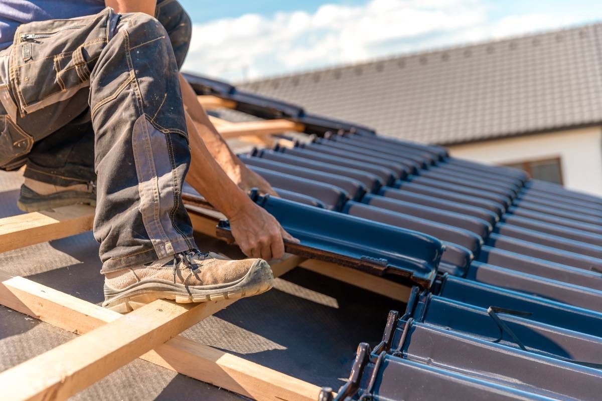 A professional roofing contractor working on installing a new roof for a residential home