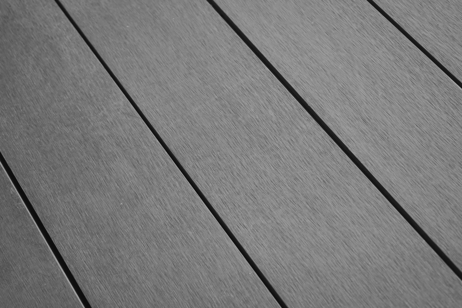 An up-close image of composite decking boards in a gray color and a diagonal perspective
