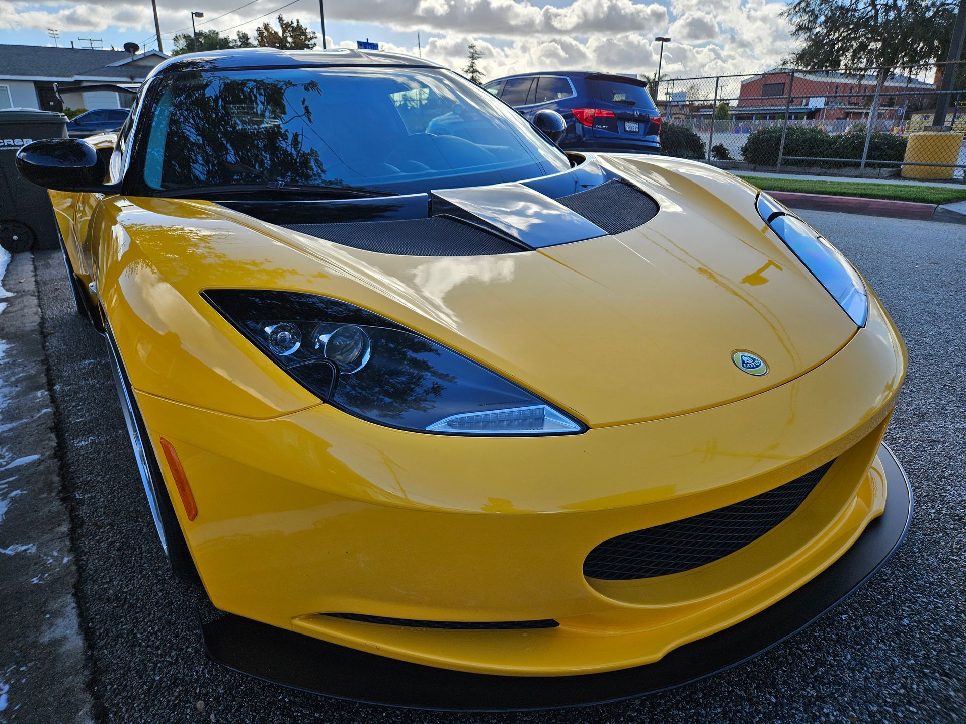 A yellow sports car is parked on the side of the road.