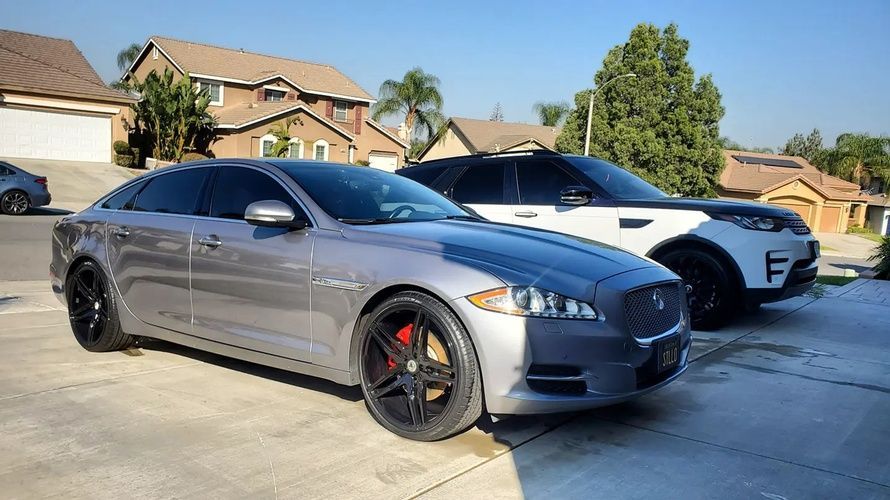 Two cars are parked next to each other in a driveway.