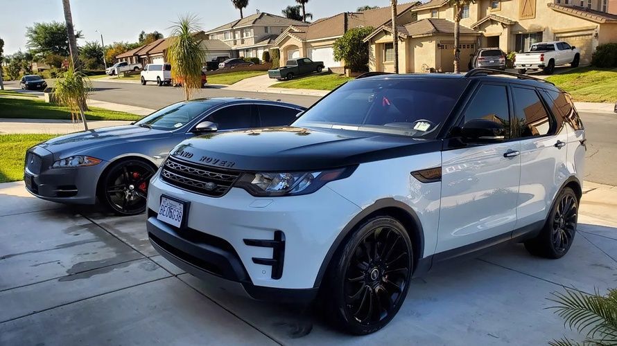 Two cars are parked next to each other in a driveway.
