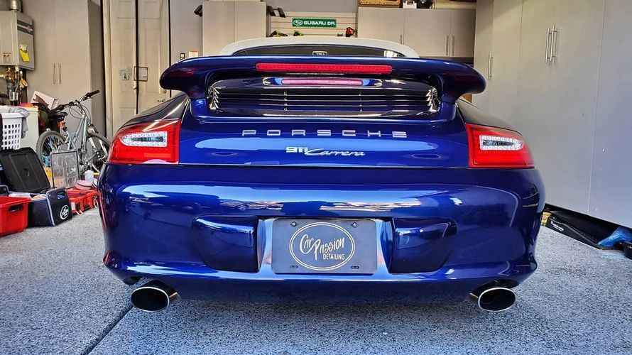 A blue porsche is parked in a garage