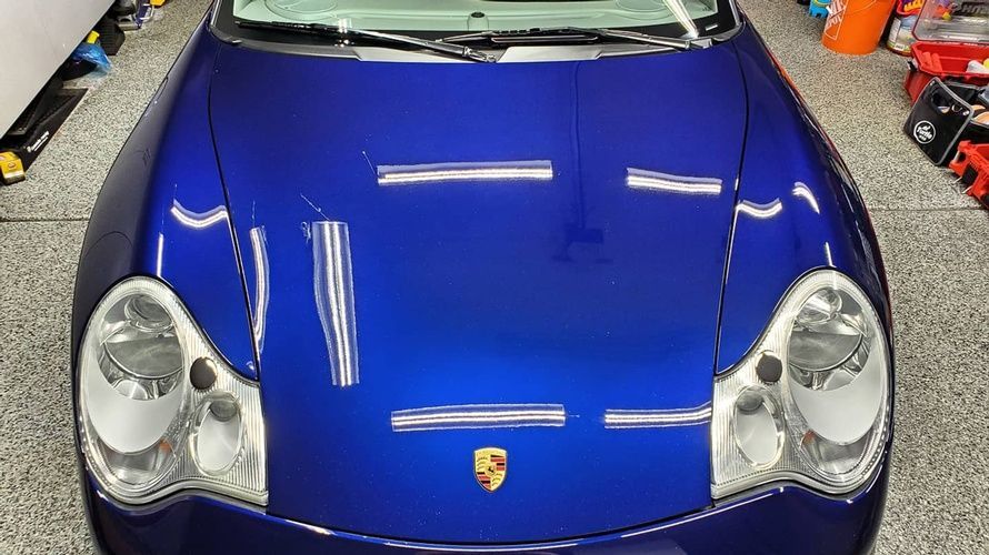 A blue porsche is parked in a garage.