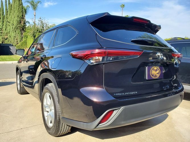 A black toyota highlander is parked on the side of the road.