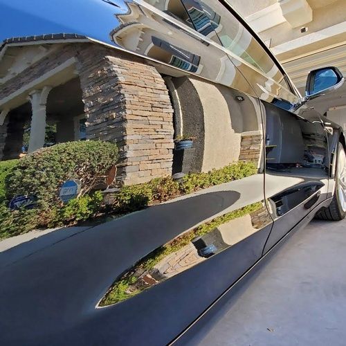 A car is parked in a driveway in front of a house.