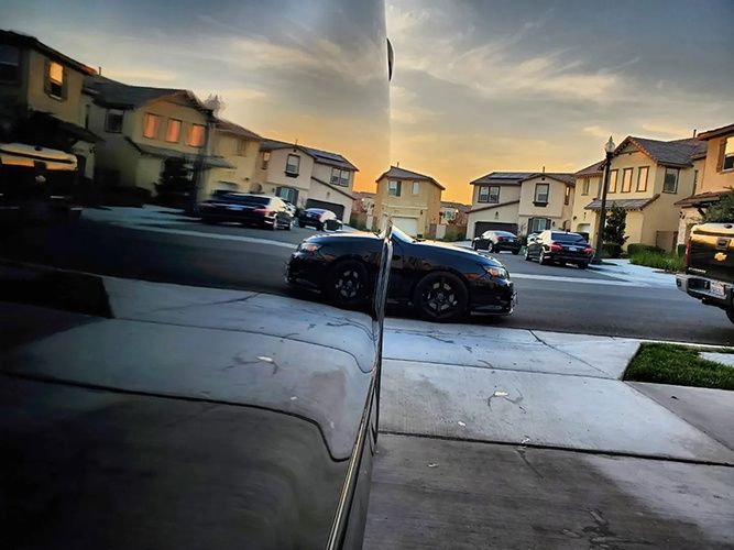 A car is parked on the side of the road in a residential neighborhood.
