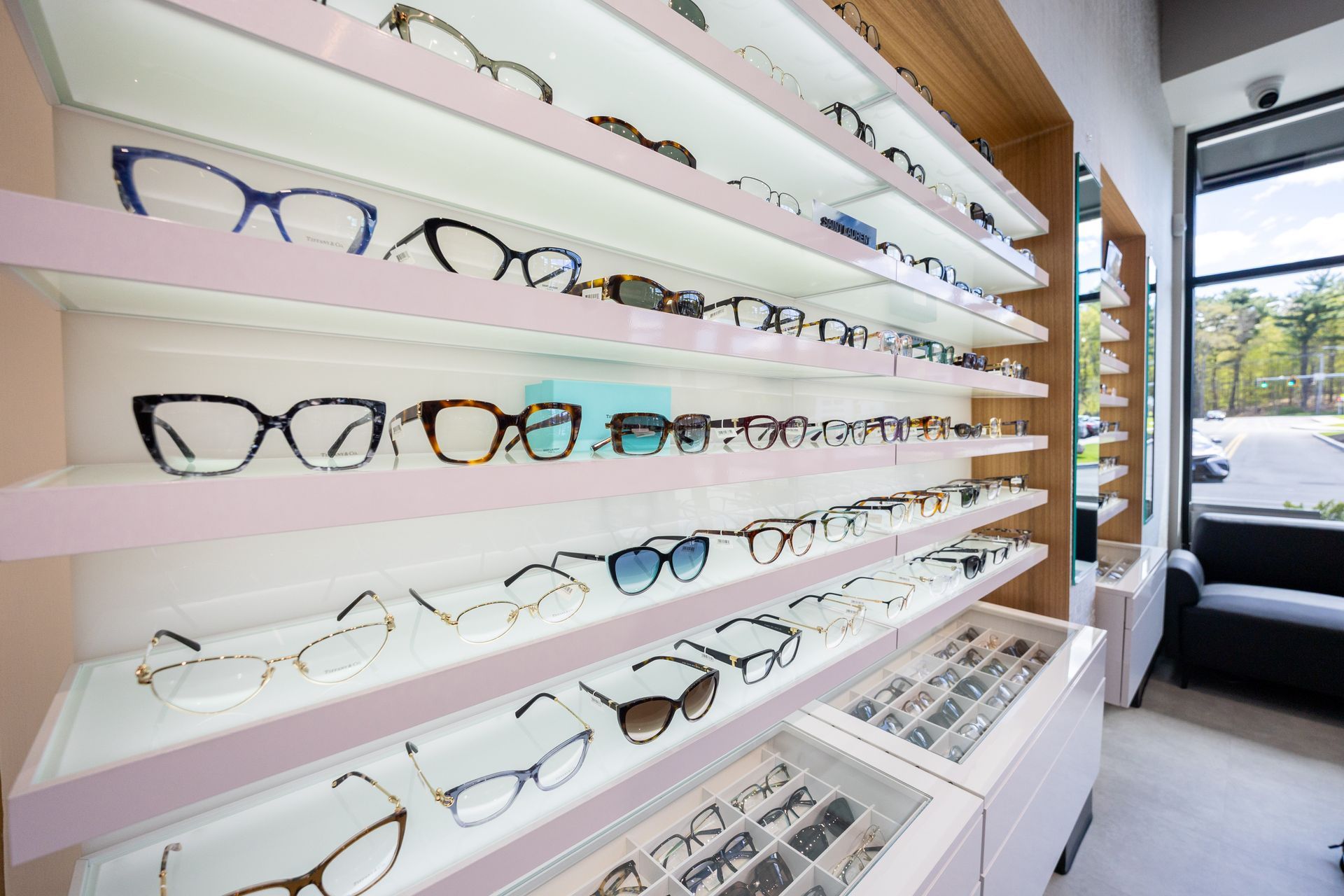 Eyeglass frames displayed on illuminated shelves in an optical shop