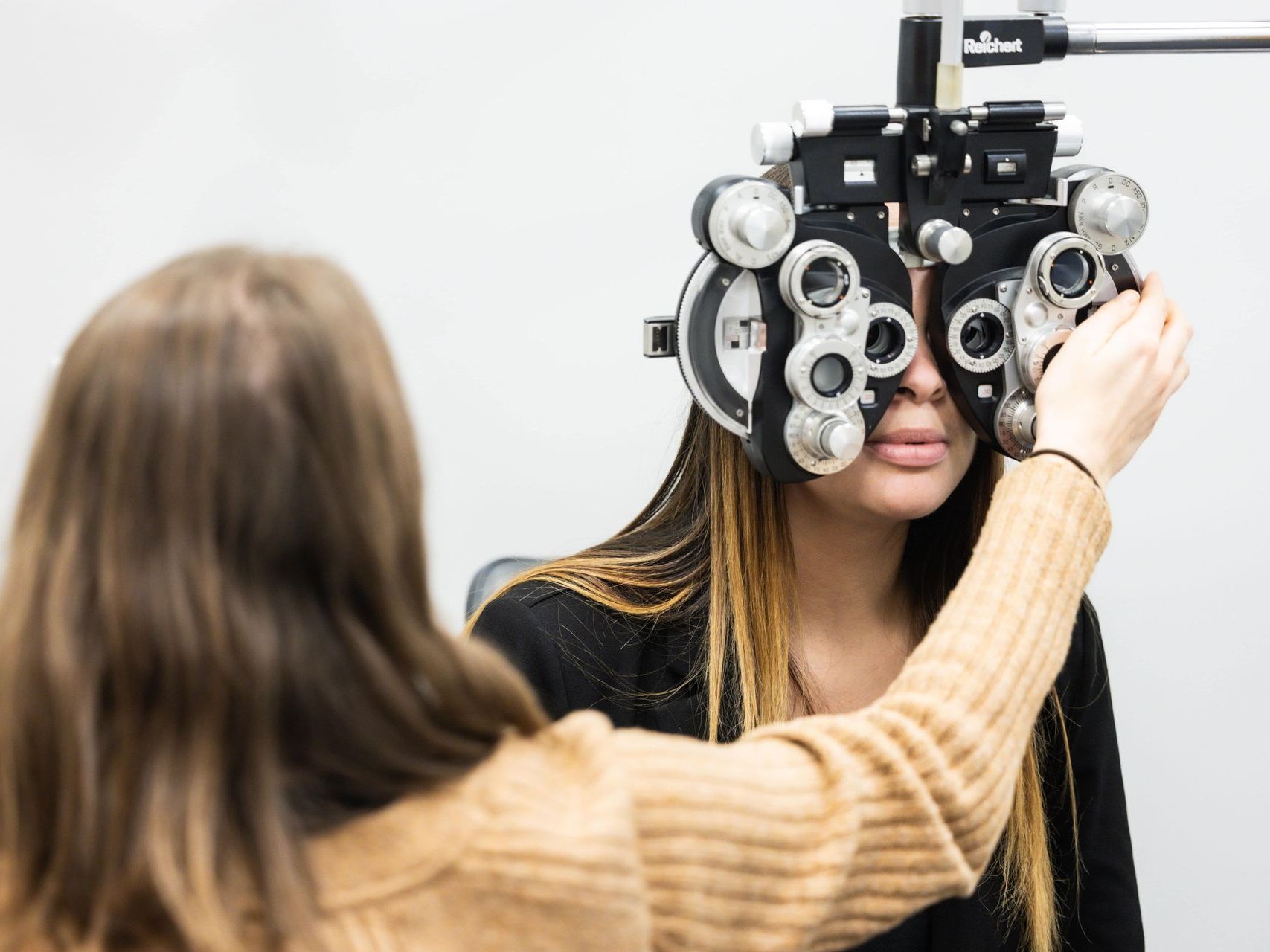 An image of a woman is getting her eyes checked by an ophthalmologist