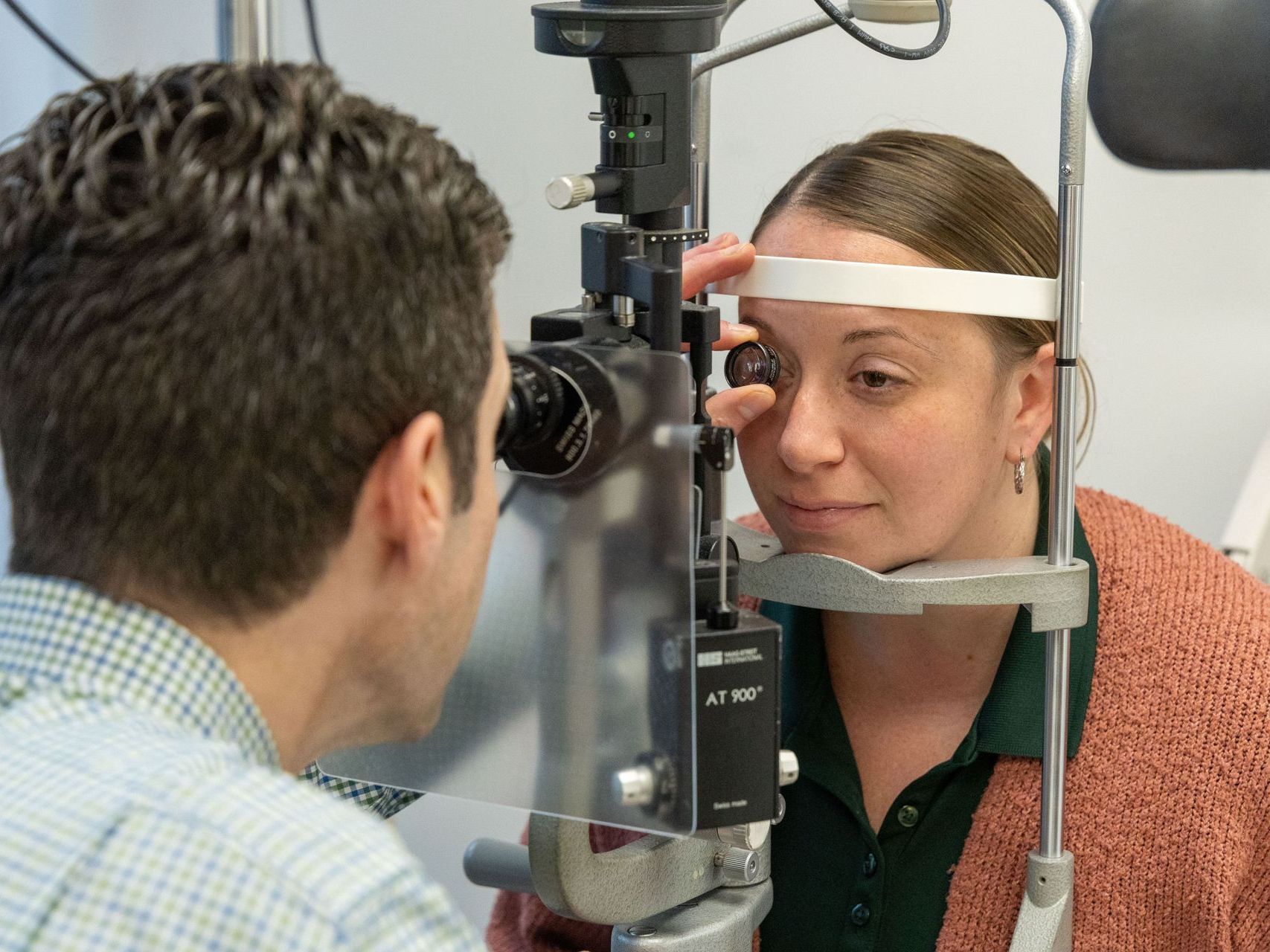 An image of a woman is getting her eyes examined by an ophthalmologist