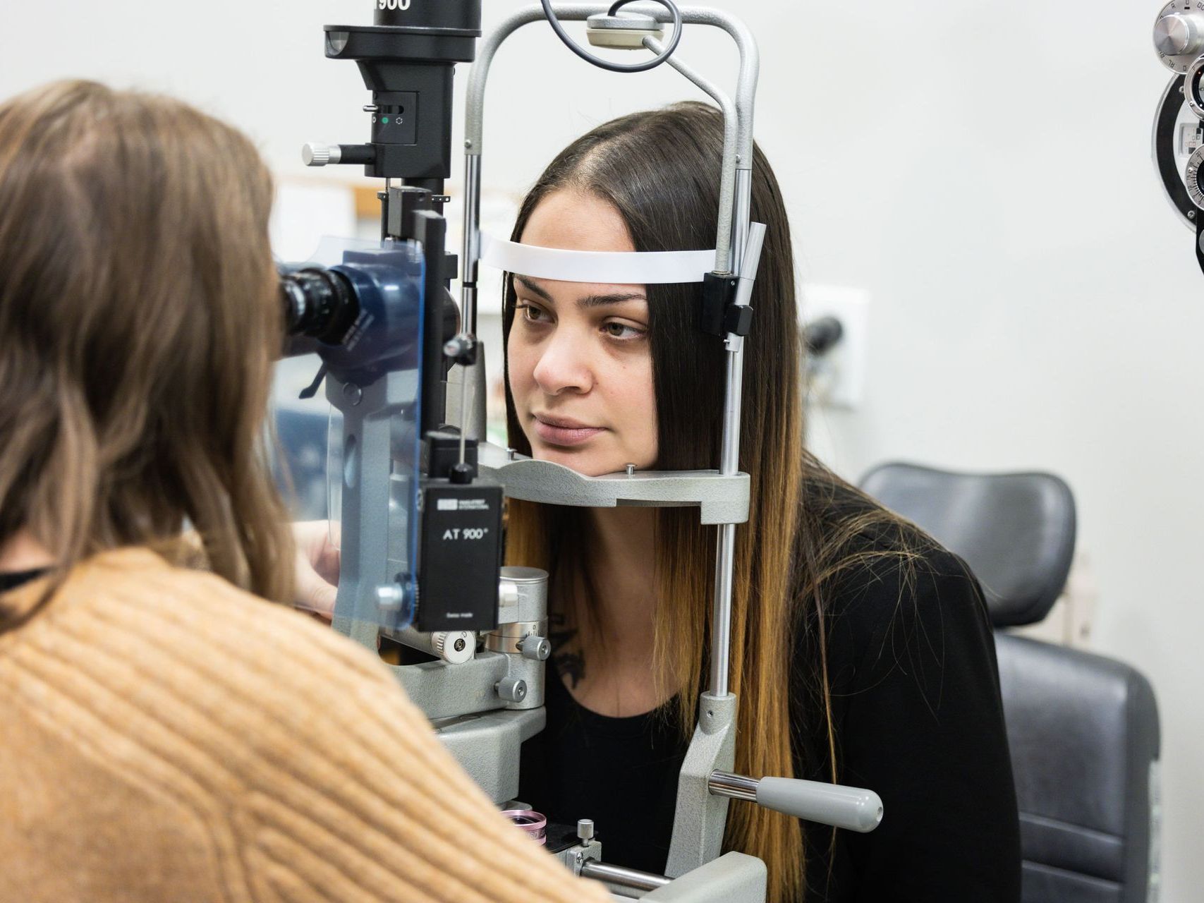 An image of a woman is getting her eyes examined by an ophthalmologist