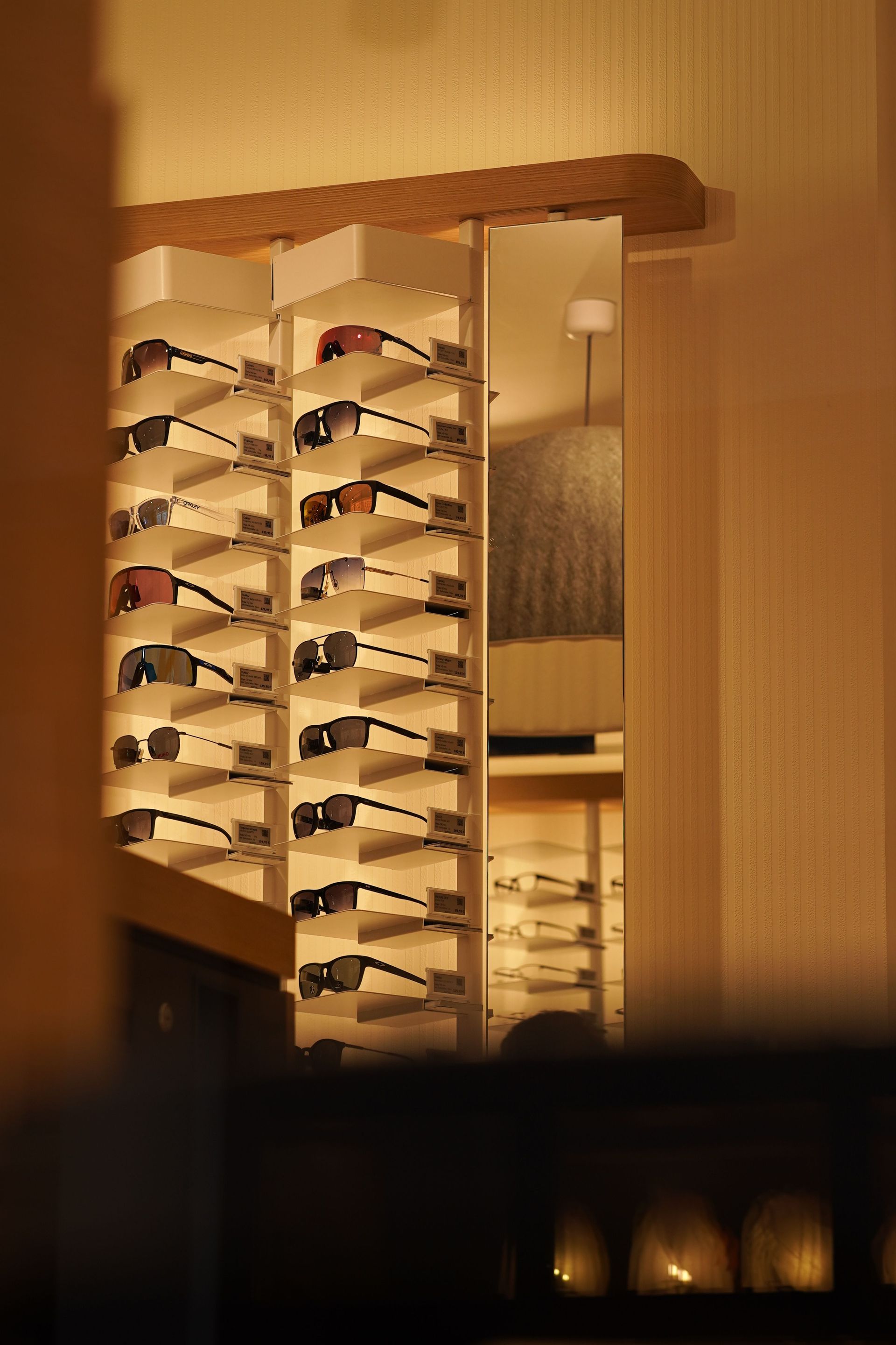 Warm-lit mirrored wall with stacked shelves and lamps in a cozy interior