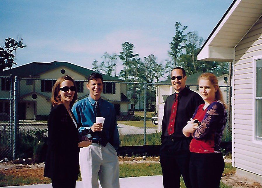 A group of people standing in front of a house