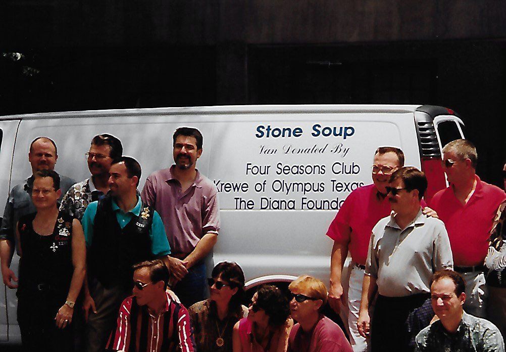 A group of people standing in front of a van that says stone soup