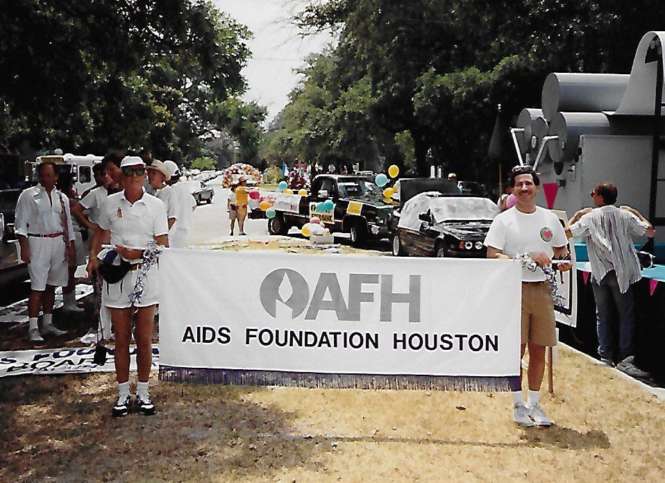 People standing in front of a sign that says aids foundation houston
