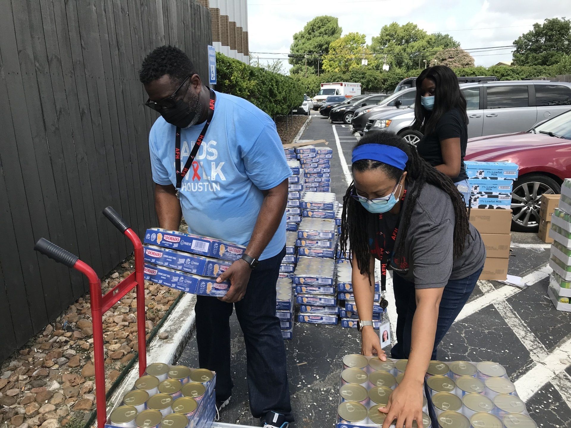 A man and a woman are loading boxes onto a cart.