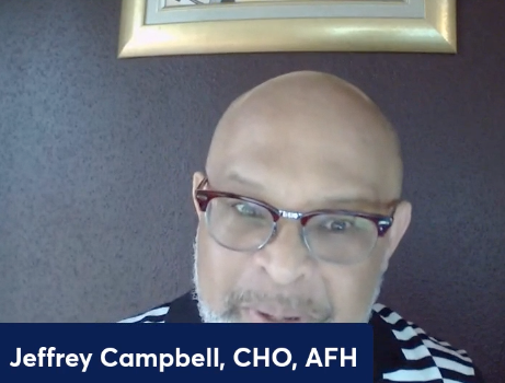 A bald man with glasses and the name jeffrey campbell