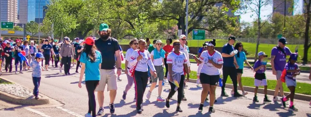 A large group of people are walking down a street.
