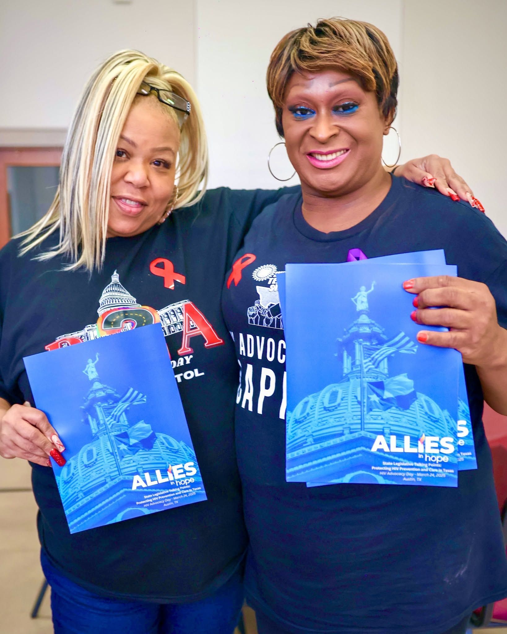 two fem-presenting AIH volunteers holding posters
