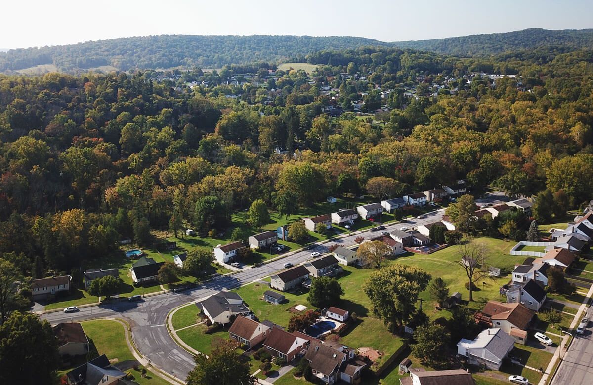 An aerial view of a residential area surrounded by trees and houses.