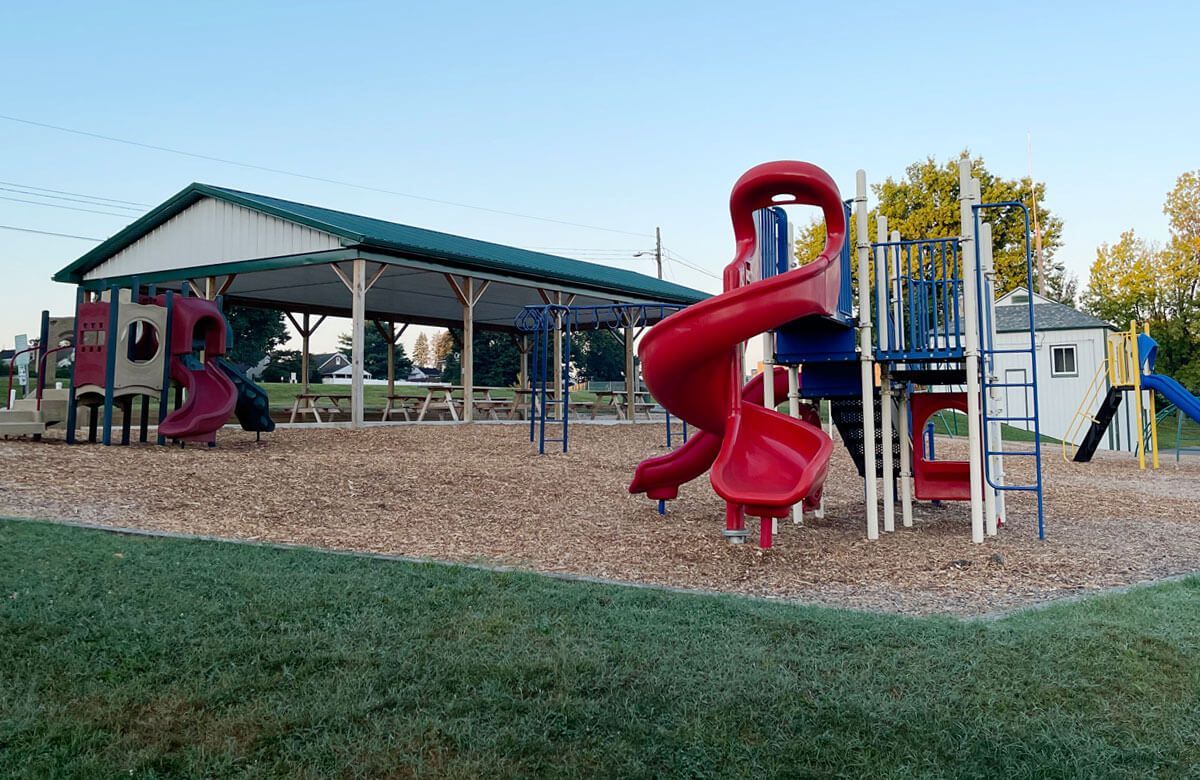 A playground with a red slide and a blue slide