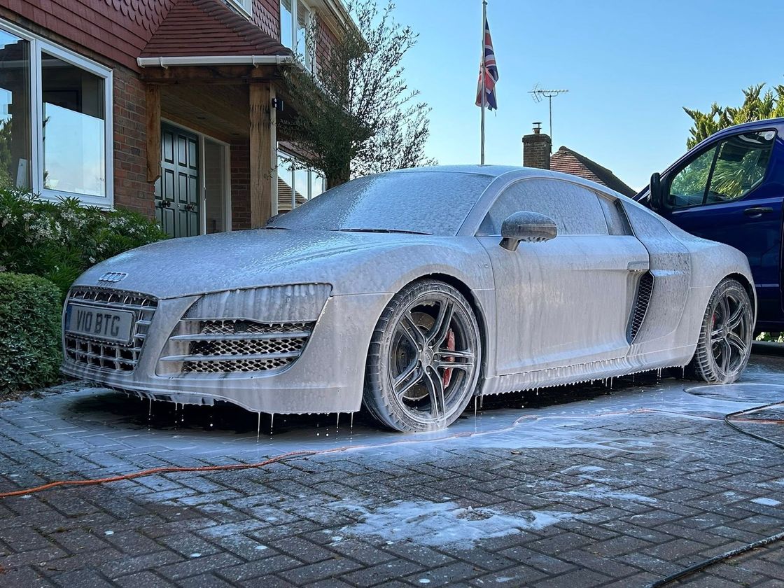 Gleaming dark-blue saloon car after hand wash