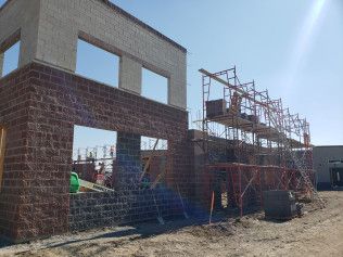A building is being built with bricks and scaffolding.