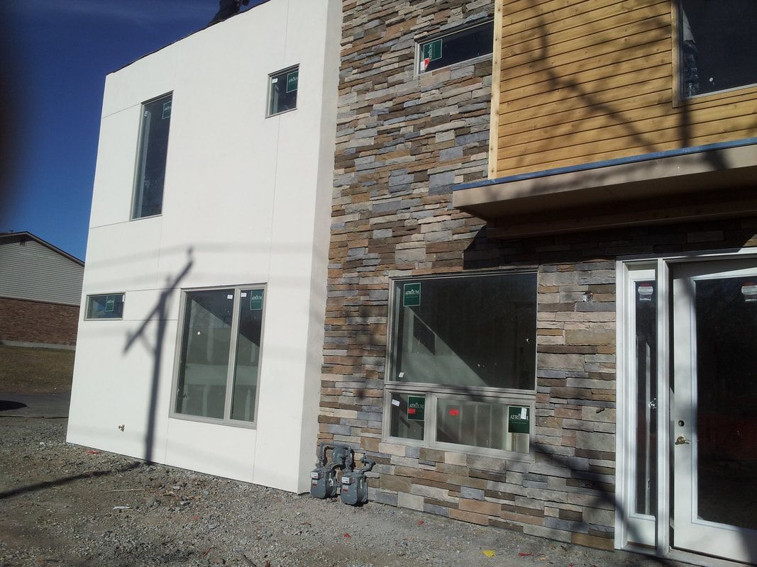 A white building with a stone facade and a white door