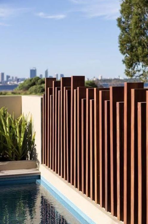 Modern Poolside Patio With Wood Slat Fence and City Skyline Beyond — RYDALL BUILDING AND DEVELOPMENT in Freshwater, QLD