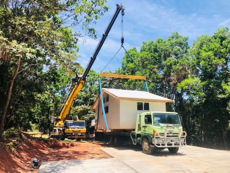 Crane Lifting a Small House Onto a Flatbed Truck — RYDALL BUILDING AND DEVELOPMENT in Freshwater, QLD