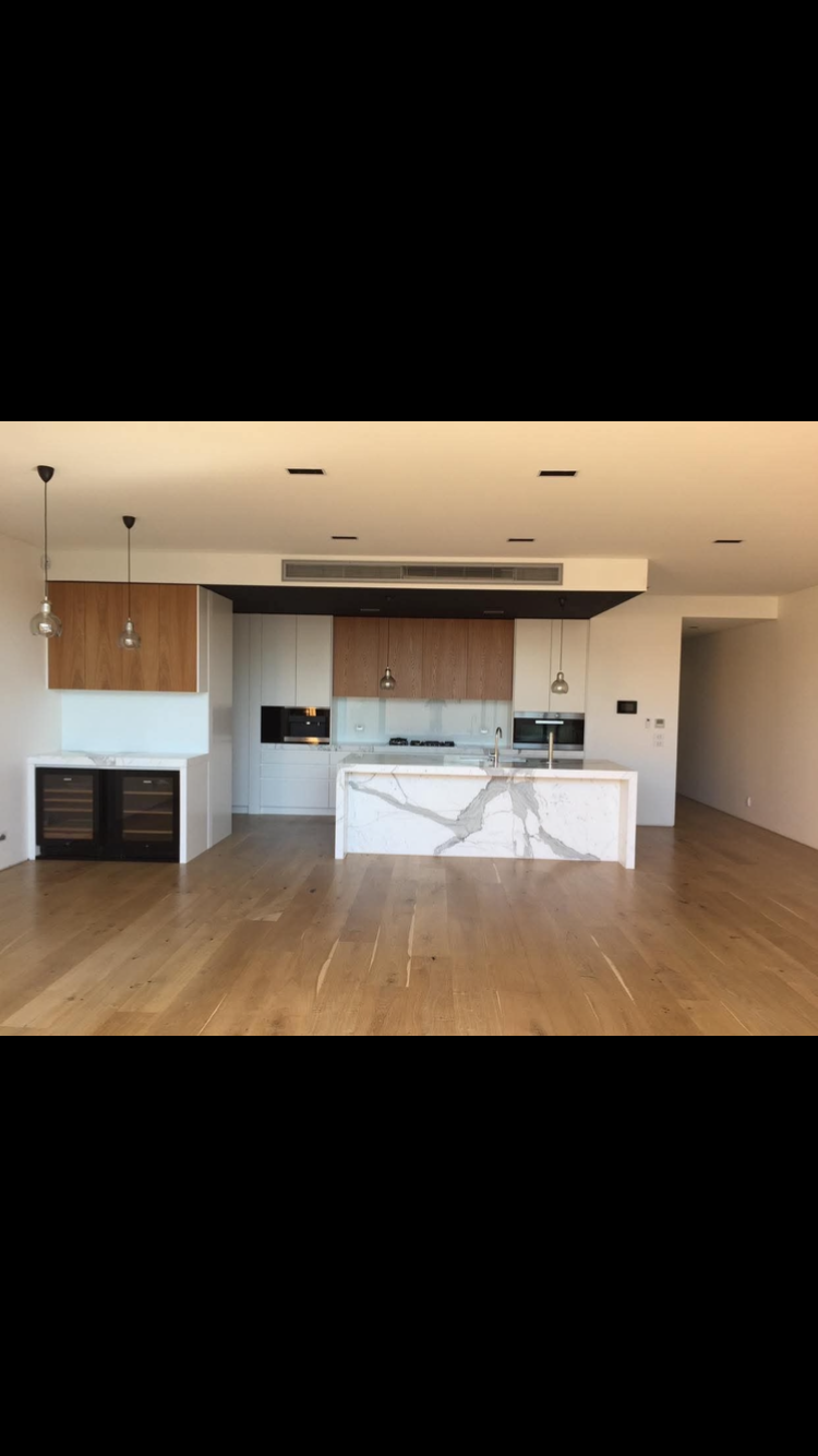 Empty Modern Apartment Kitchen and Living Area With Wood Floors — RYDALL BUILDING AND DEVELOPMENT in Freshwater, QLD