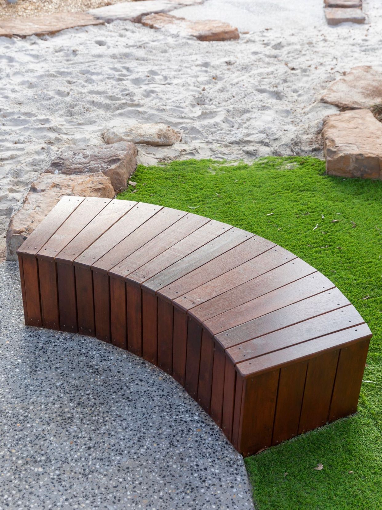 Curved Wooden Bench Beside Green Grass and Gravel — RYDALL BUILDING AND DEVELOPMENT in Freshwater, QLD