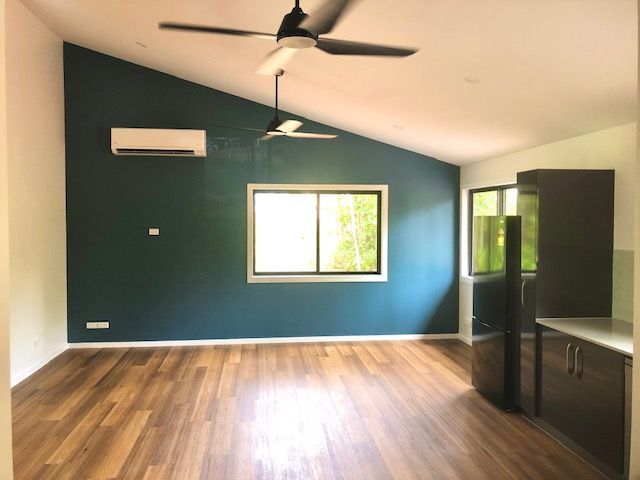 Empty Modern Room With Teal Accent Wall and Wood Floor — RYDALL BUILDING AND DEVELOPMENT in Freshwater, QLD