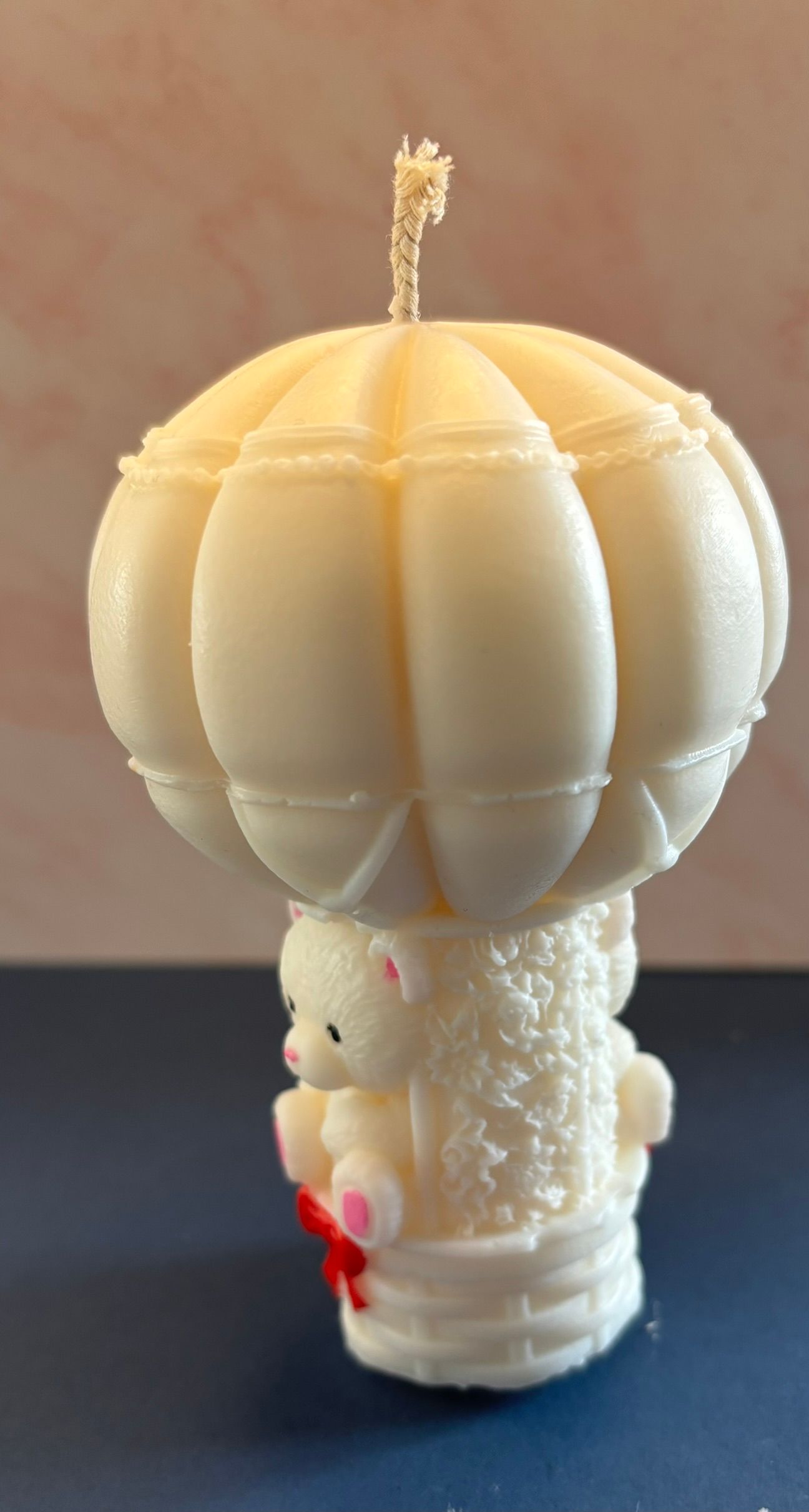 Klein decoratief wit kaarsje in de vorm van een heteluchtballon met een klein beertje in het mandje.