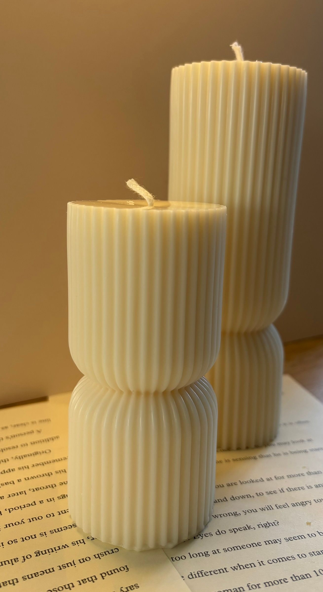 twee elegante sculptuurkaarsen met geribbeld ontwerp en moderne zuilvorm.