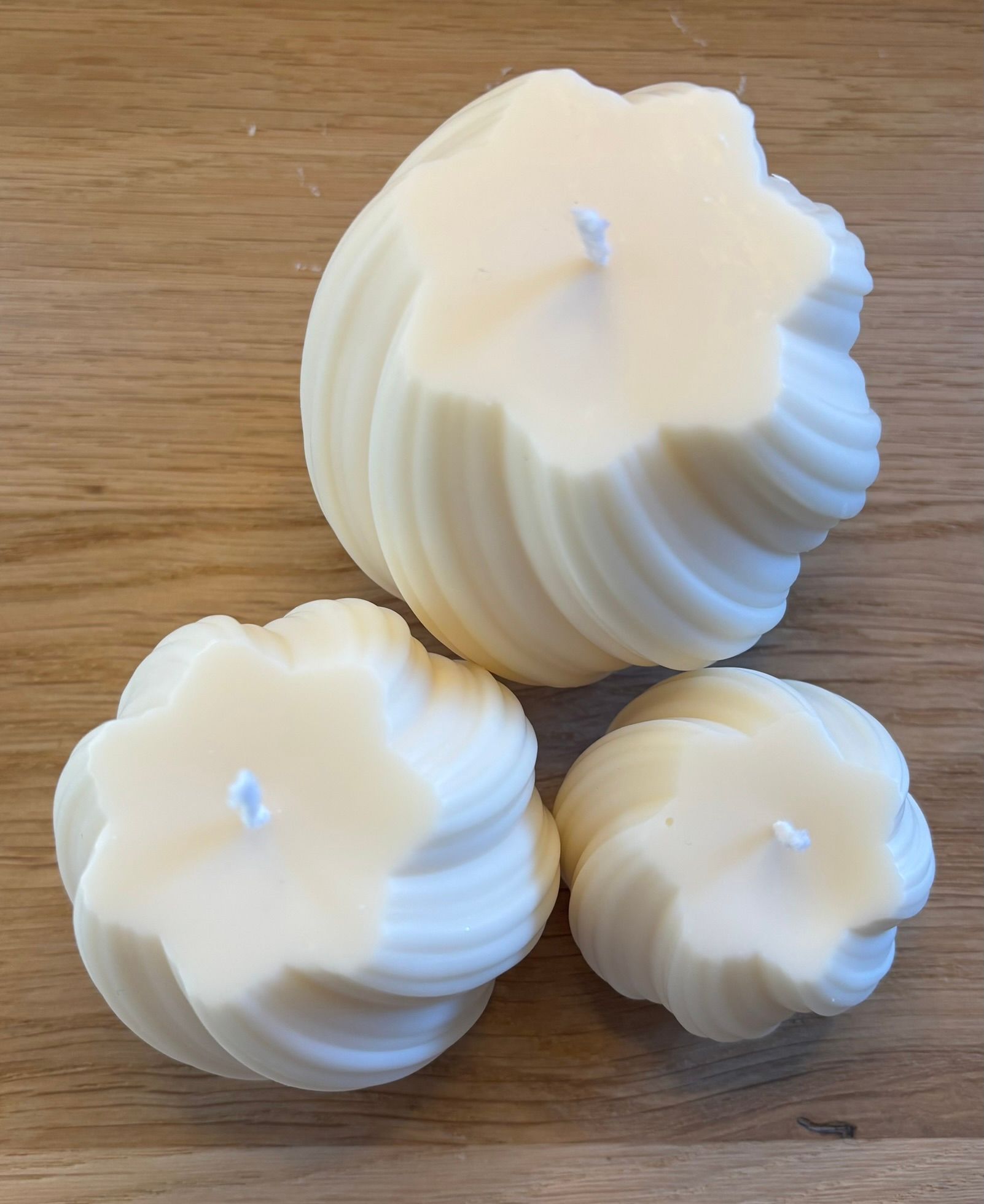Drie handgemaakte Twisted Pillar kaarsen van ivoorwitte sojawas in Small, Medium en Large met een elegant gedraaid design.