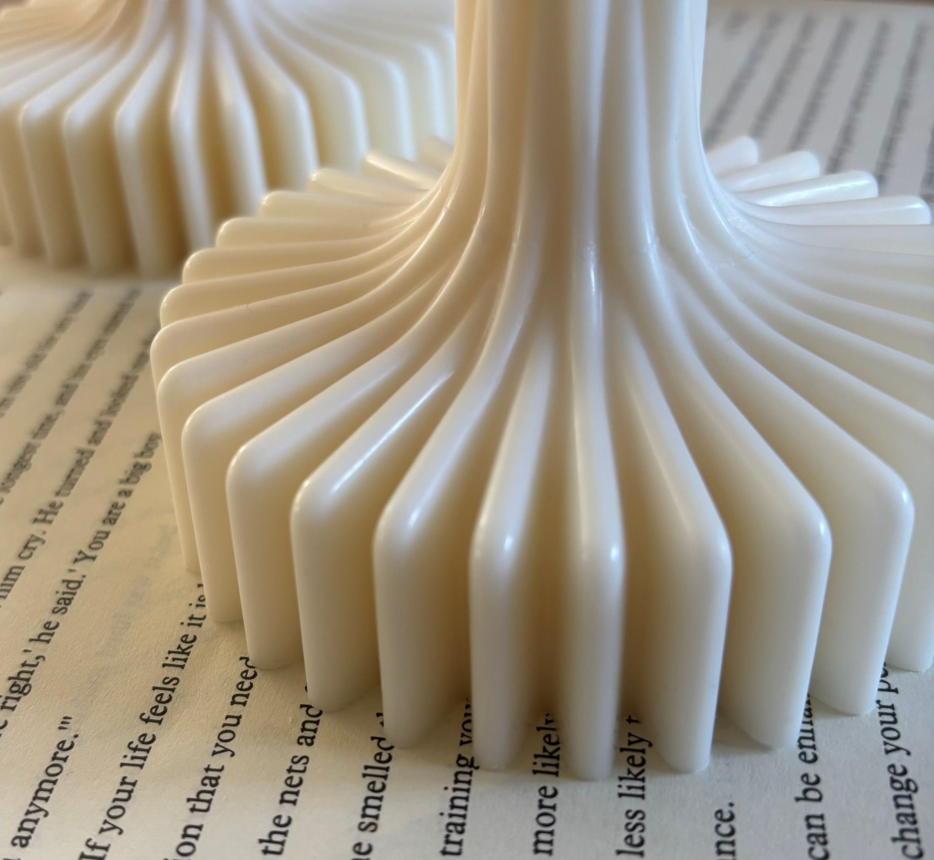 Twee witte sculptuurkaarsen met bloemachtige voet