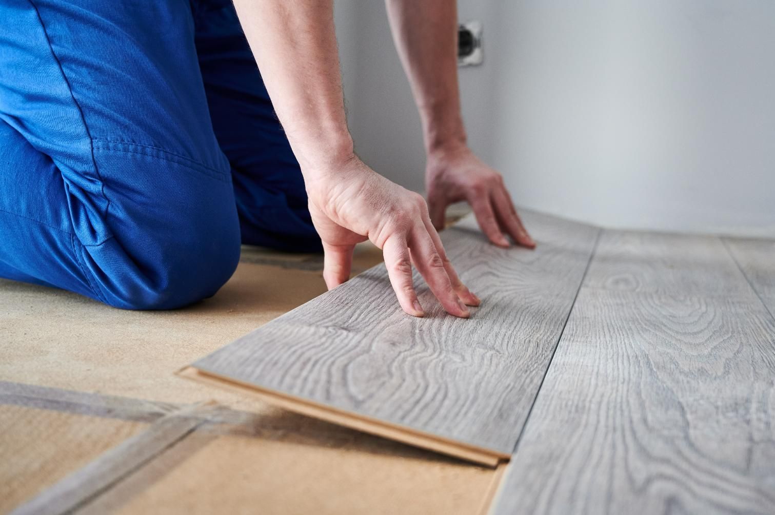A Person is Installing a Wooden Floor in a Room — Taggerts Discount Carpets & Vinyls In California Gully, VIC