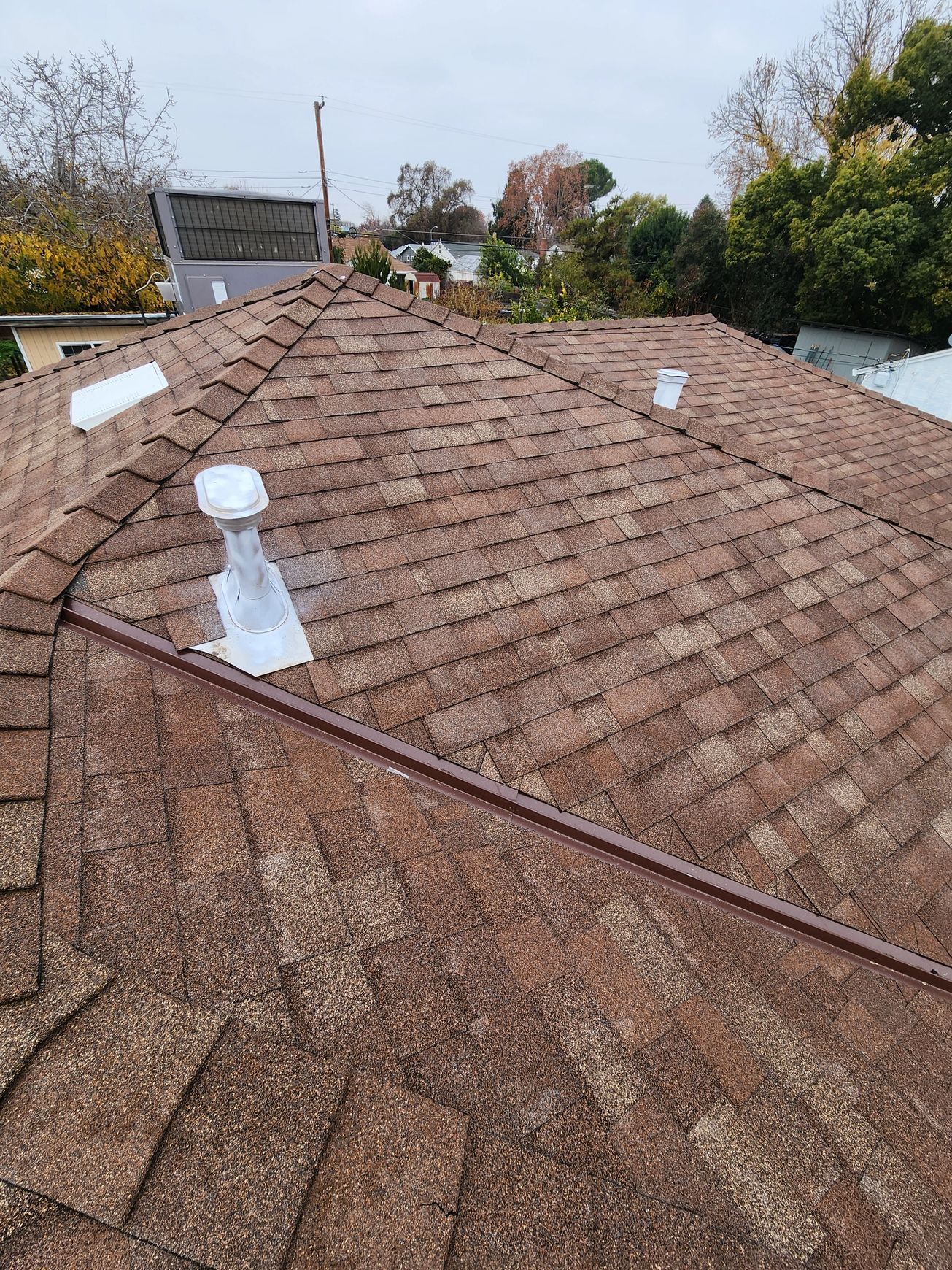 A close up of a roof with a vent on it.