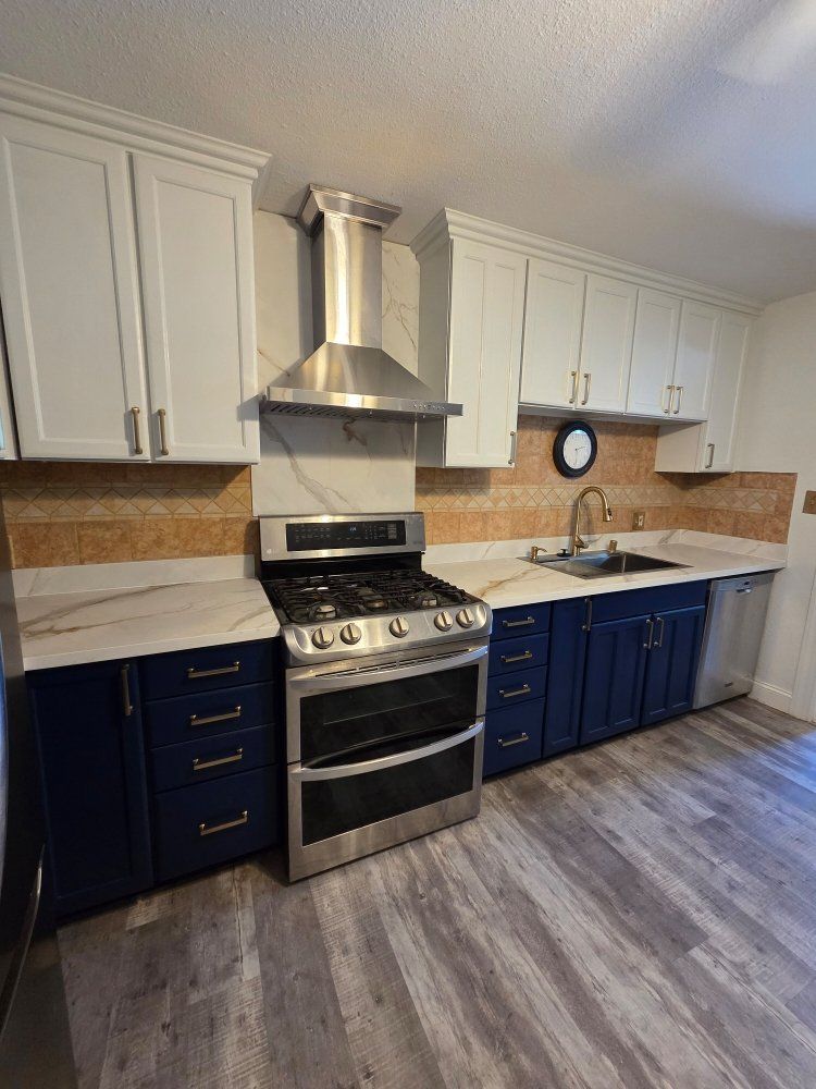 A kitchen with blue cabinets , a stove and a sink.