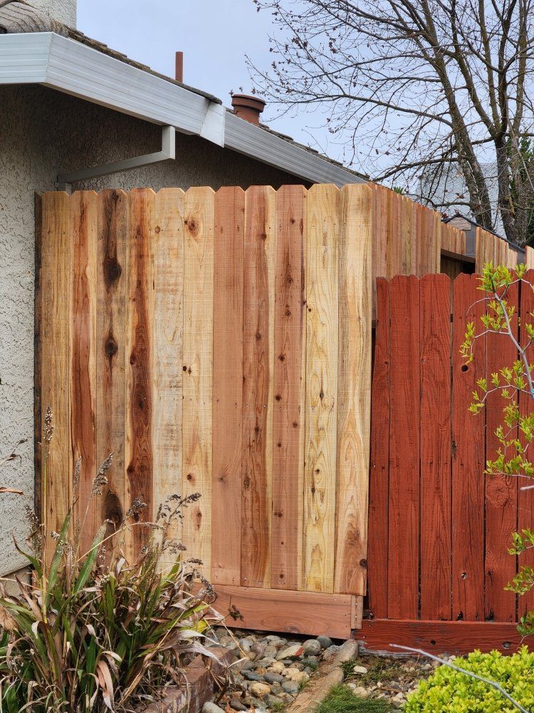 A wooden fence is sitting in front of a house.