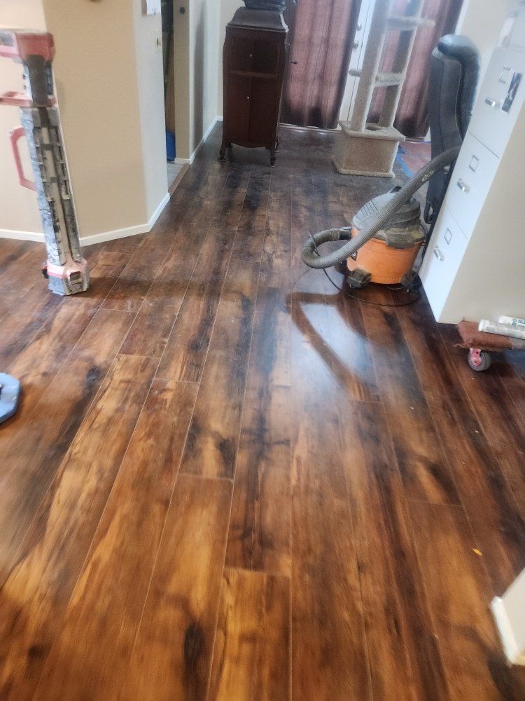 A vacuum cleaner is sitting on a wooden floor in a living room.