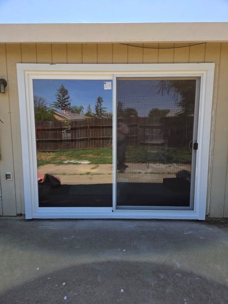 A sliding glass door is sitting on the side of a house.