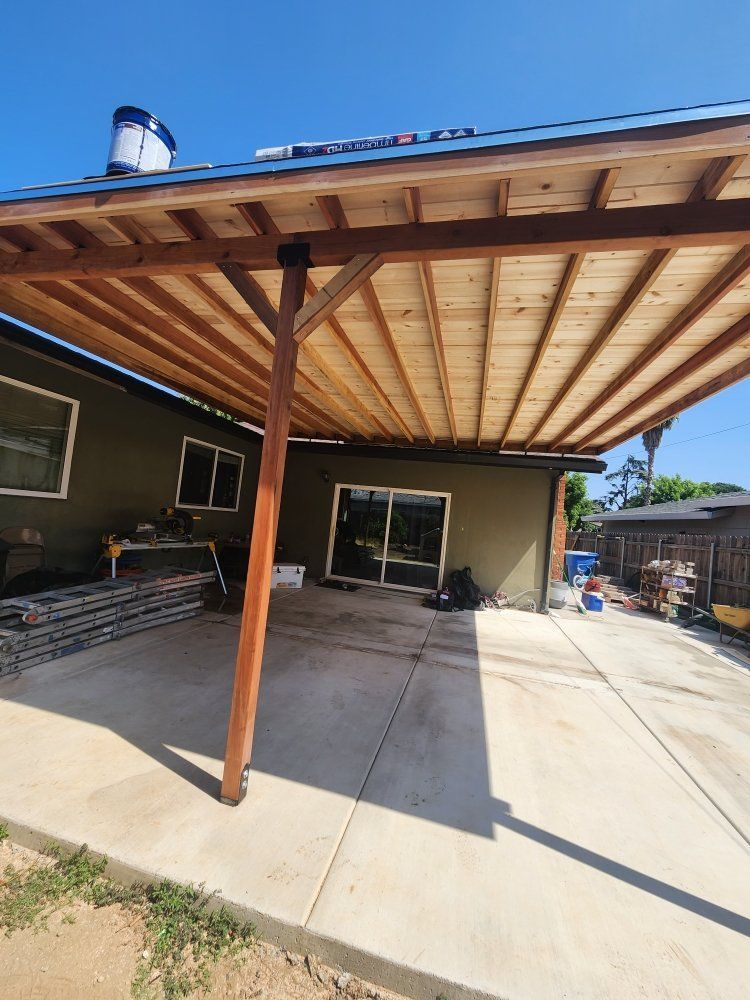 A house with a wooden covered patio in front of it.