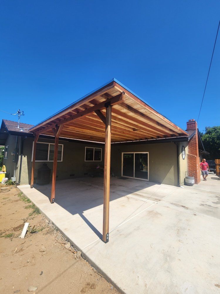 A house with a wooden covered patio in front of it.