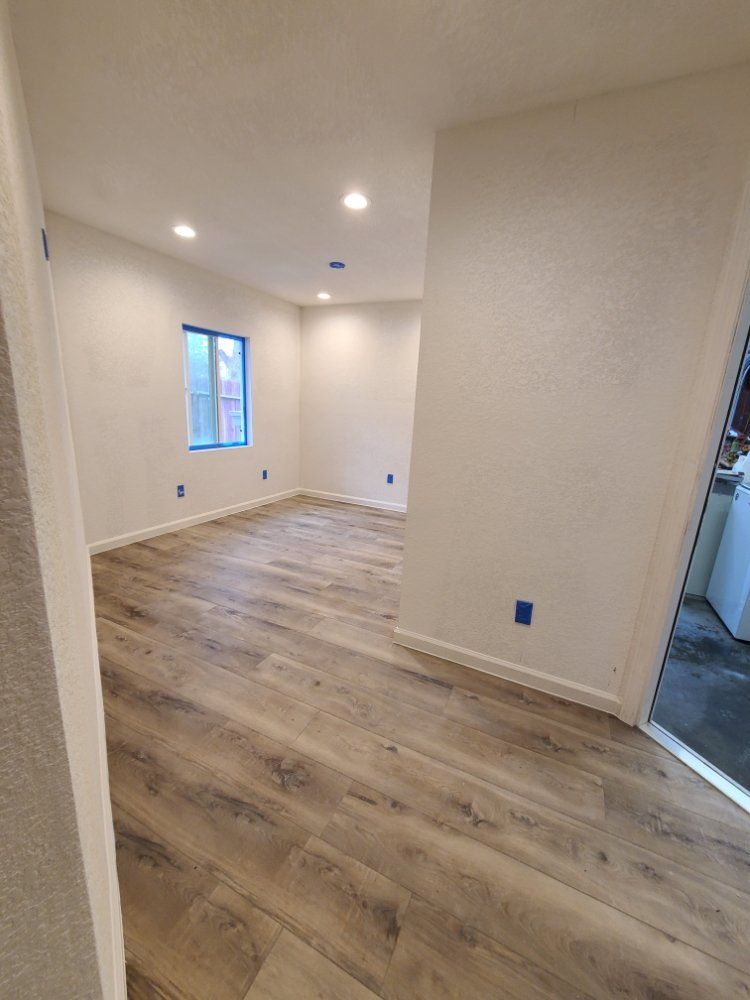 A living room with hardwood floors and white walls.