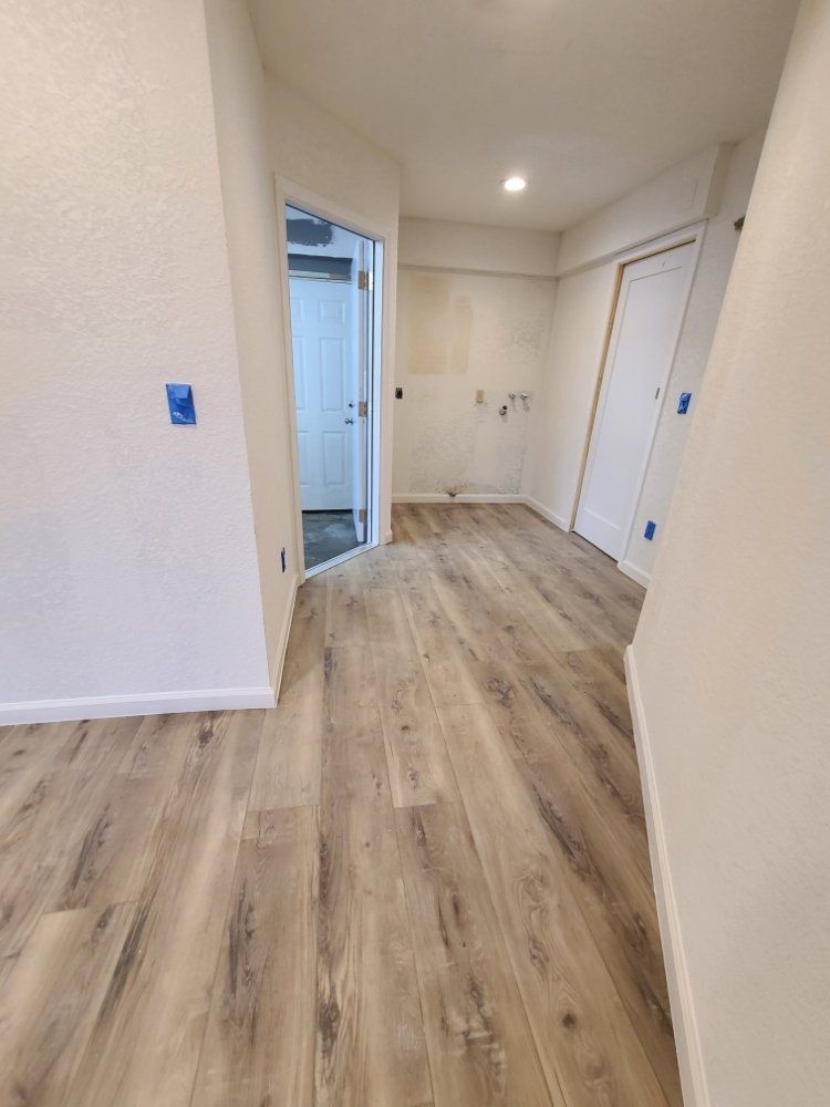 An empty room with hardwood floors and white walls.