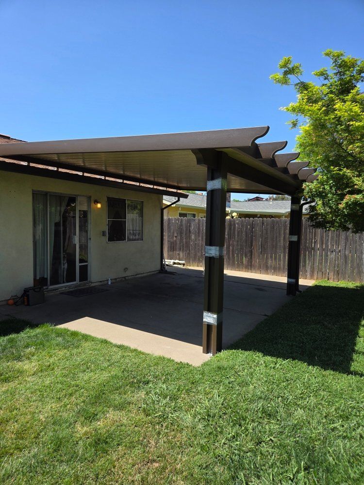 There is a pergola in the backyard of a house.