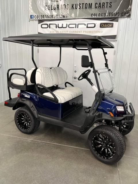 Blue golf cart with black roof and white seats displayed indoors at a custom carts showroom